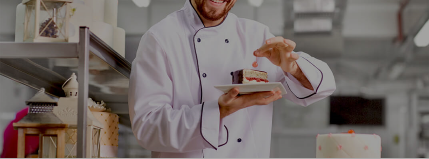 Chef placing a cherry on a dessert